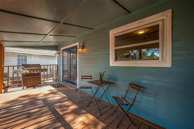 wooden deck featuring french doors and a grill