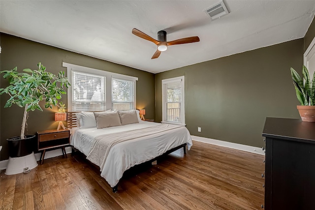 bedroom featuring a ceiling fan, baseboards, visible vents, and dark wood-style flooring