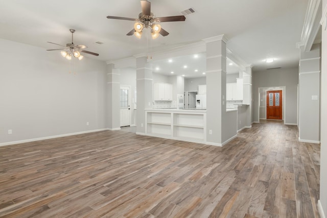 unfurnished living room with light wood finished floors, visible vents, and baseboards