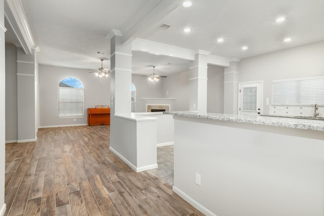 kitchen featuring ceiling fan, a fireplace, visible vents, open floor plan, and light wood-type flooring