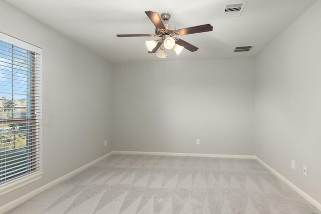 unfurnished room featuring baseboards, ceiling fan, visible vents, and light colored carpet