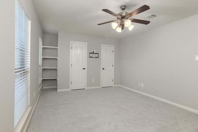 unfurnished bedroom with carpet, visible vents, ceiling fan, and baseboards