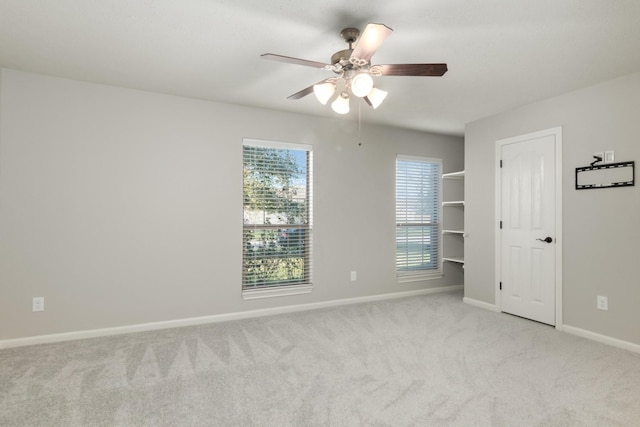 unfurnished bedroom with a ceiling fan, light carpet, and baseboards