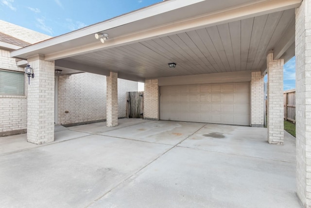 view of patio / terrace with a carport, fence, and a garage