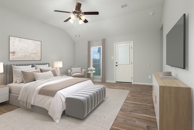 bedroom featuring wood finished floors, a ceiling fan, visible vents, vaulted ceiling, and baseboards