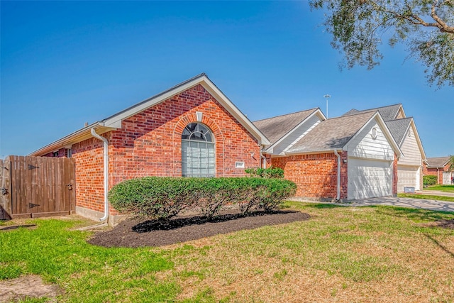 single story home with a front yard, a garage, a gate, and brick siding