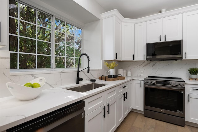 kitchen with a sink, black dishwasher, white cabinetry, and electric stove