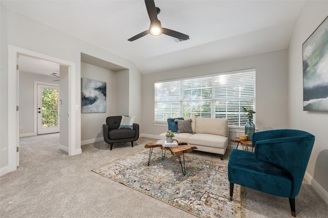 living room with light carpet, ceiling fan, baseboards, and vaulted ceiling