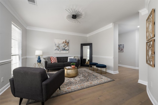 living area with ornamental molding, visible vents, baseboards, and wood finished floors