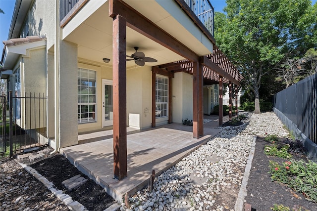 view of patio / terrace with ceiling fan and fence