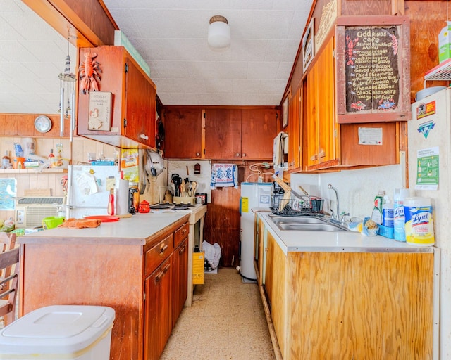 kitchen with brown cabinets, light floors, light countertops, and a sink