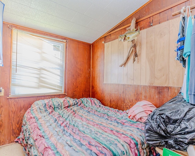 bedroom with wooden walls and vaulted ceiling