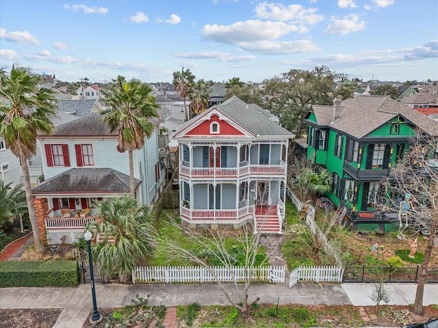 view of front of property featuring a porch, a residential view, and a fenced front yard