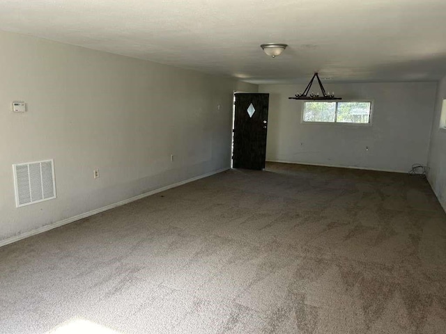 carpeted empty room featuring visible vents