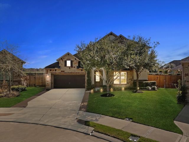 view of property hidden behind natural elements with a garage, fence, a yard, stone siding, and driveway