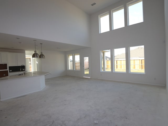 8502 Pier Cove Dr, Cypress, TX 77433 - unfurnished living room with a sink, a towering ceiling, plenty of natural light, and baseboards