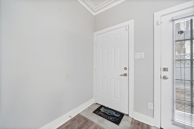 entryway featuring light wood-type flooring, crown molding, and baseboards