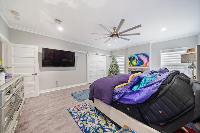 bedroom featuring a barn door, multiple windows, light wood-style flooring, and crown molding