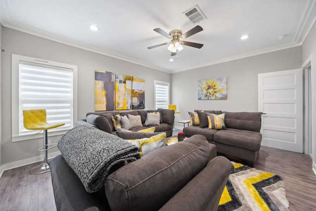 living area featuring dark wood-style floors, crown molding, visible vents, a ceiling fan, and baseboards