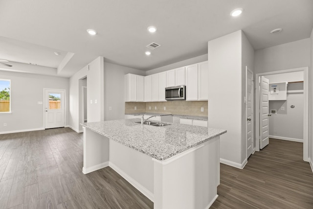16539 Willow Forest Dr, Conroe, TX 77302 - kitchen featuring stainless steel microwave, a sink, light stone countertops, dark wood finished floors, and recessed lighting