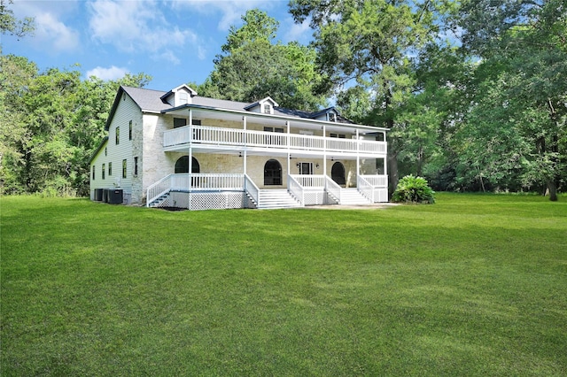 rear view of house with central AC unit, a lawn, a balcony, stairs, and a porch