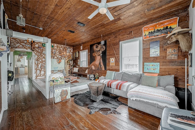 living area with wooden ceiling, wood walls, hardwood / wood-style flooring, and a ceiling fan
