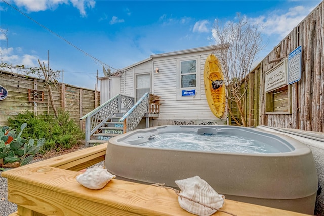 exterior space featuring a hot tub and fence