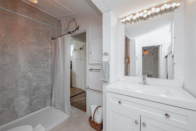 bathroom with tile patterned flooring, vanity, and a shower stall