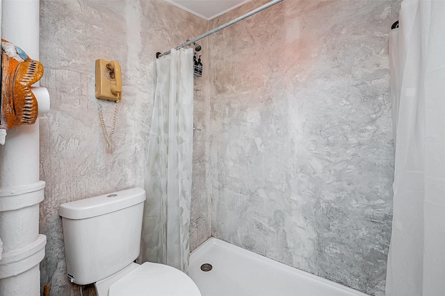 full bathroom with a tile shower and toilet