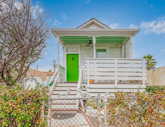 shotgun-style home with a fenced front yard