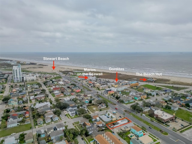 birds eye view of property with a water view and a beach view