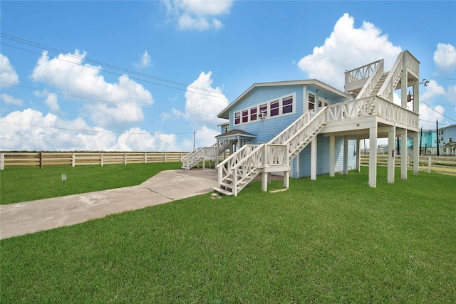 back of property with a lawn and stairs