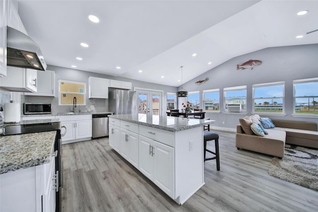 kitchen featuring a center island, pendant lighting, appliances with stainless steel finishes, open floor plan, and white cabinets