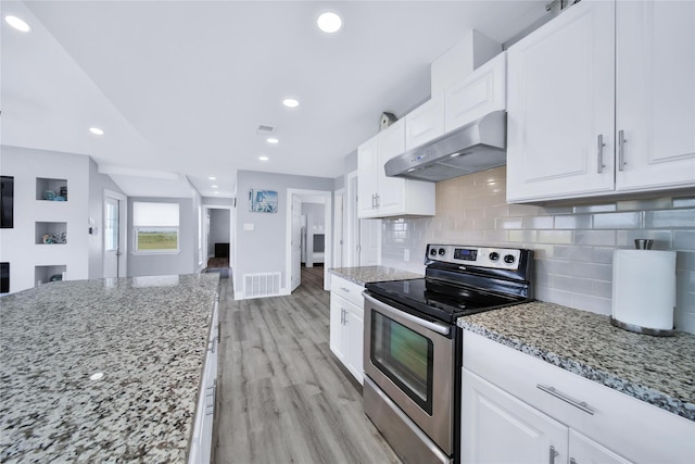 kitchen featuring white cabinets, visible vents, ventilation hood, and stainless steel range with electric cooktop