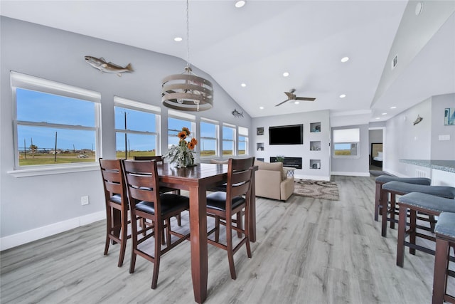 dining area with lofted ceiling, light wood finished floors, and a healthy amount of sunlight