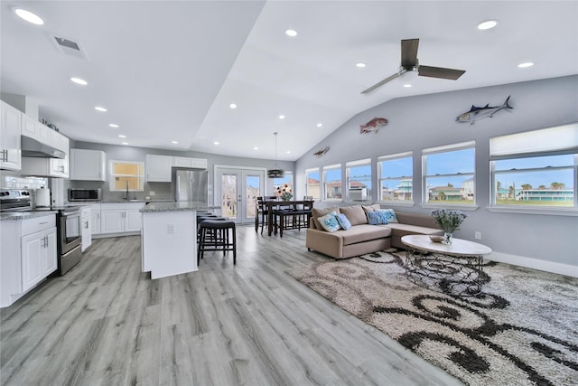 living area featuring visible vents, baseboards, light wood-style flooring, vaulted ceiling, and recessed lighting