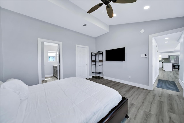 bedroom featuring light wood-type flooring, visible vents, baseboards, and stainless steel refrigerator