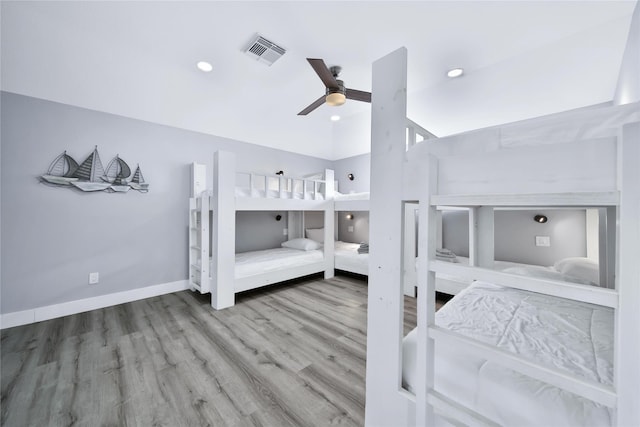 bedroom featuring lofted ceiling, recessed lighting, wood finished floors, visible vents, and baseboards