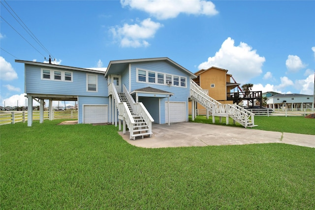 coastal inspired home with stairs, driveway, a front yard, and a garage