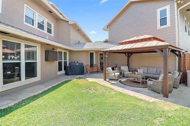 rear view of property with a yard, a patio, stucco siding, a gazebo, and an outdoor living space