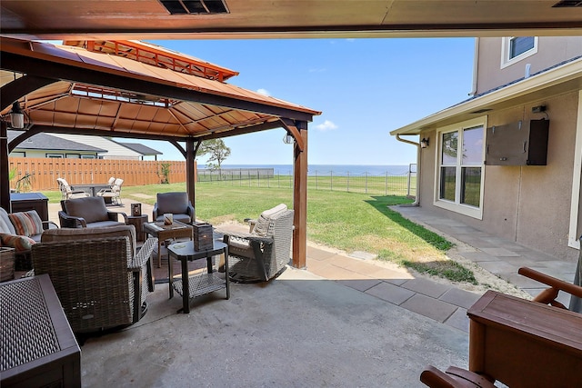 view of patio / terrace featuring a water view, a fenced backyard, a gazebo, and an outdoor hangout area