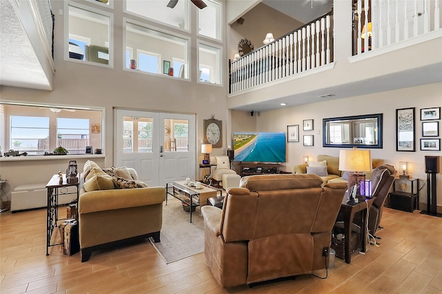 living area featuring light wood-style floors, french doors, and a ceiling fan