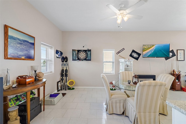 dining space with plenty of natural light, a ceiling fan, and baseboards