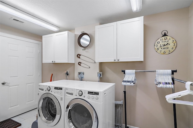 laundry room with washer and dryer, cabinet space, visible vents, and light tile patterned flooring