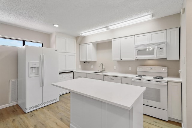 kitchen with white cabinets, white appliances, visible vents, and light countertops