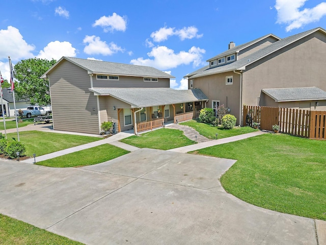 view of front of house with driveway, fence, a porch, and a front yard