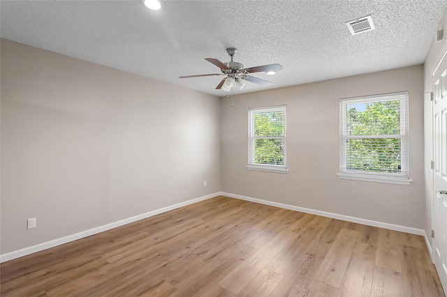 unfurnished room featuring light wood finished floors, baseboards, and visible vents