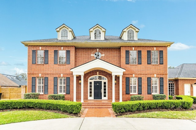 colonial inspired home with brick siding