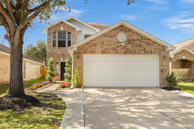 traditional home with an attached garage, driveway, and brick siding