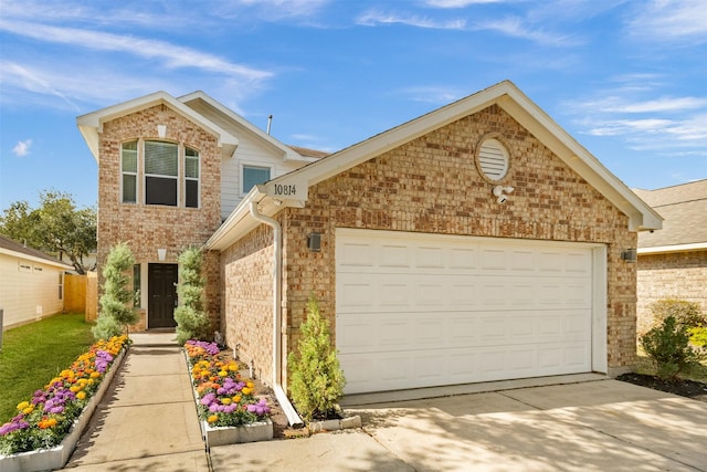 traditional home featuring a garage, brick siding, driveway, and fence